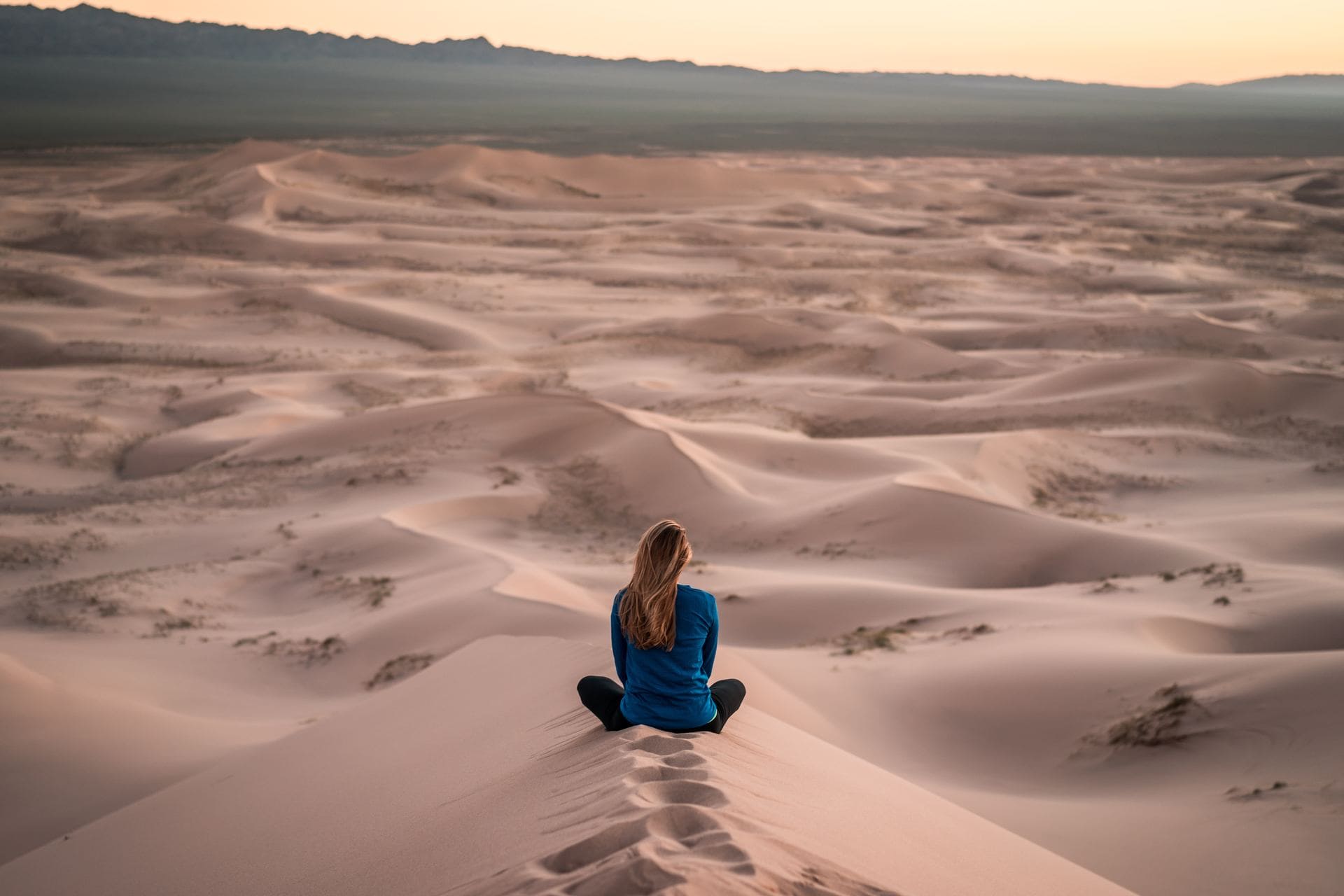 Femme assise en méditation dans le désert